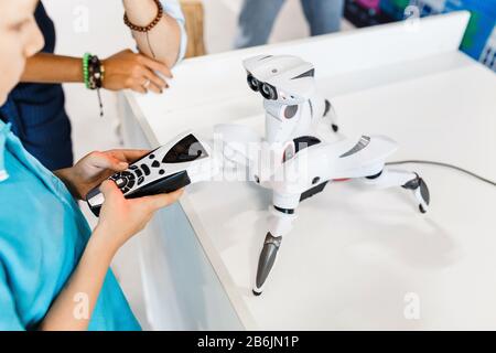 21 AGOSTO 2017, ULTRA MALL, UFA, RUSSIA: Un ragazzo costruisce e gioca con un robot in una mostra di tecnologie moderne Foto Stock