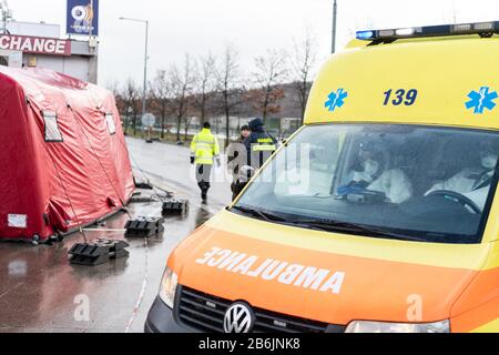 11 marzo 2020, Repubblica Ceca, Usti Nad Labem: I dipendenti del servizio di ambulanza ceco trasportano le persone in un'ambulanza dopo aver controllato i viaggiatori in una stazione di servizio sull'autostrada D8 Dresden - Praga. Per evitare la diffusione del virus corona, la Repubblica ceca ha avviato controlli casuali di viaggiatori ai confini con la Germania e l'Austria. Foto: Robert Michael/dpa-Zentralbild/dpa Foto Stock