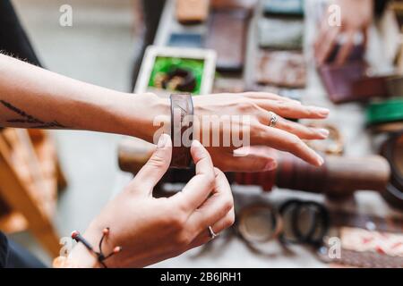 Donna scegliere i braccialetti di gioielli in pelle al mercato artigianale Foto Stock