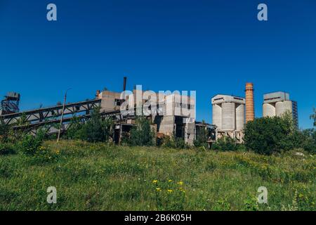 Vecchia fabbrica abbandonata overgrown di cemento armato. Foto Stock