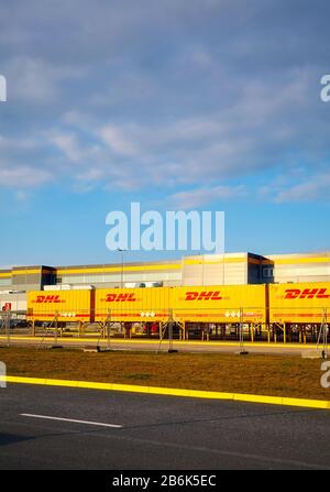 Kolbaskowo, Polonia - 05 marzo 2020: Contenitori DHL di fronte al centro di e-commerce Amazon Robotics a Kolbaskowo al tramonto. Foto Stock