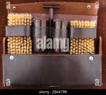 Un set da uomo vintage per la cura del corpo con spazzola per capelli, spazzola per abiti, (legno e setole) rasoio di sicurezza Bakelite, sapone da barba e contenitori per sapone da lavaggio, alloggiato in una vera custodia in pelle cucita con chiusura a pressione. Bakelite o poliossibenzilmetilenglicolanidride è stata la prima plastica sintetica sviluppata dal chimico belga-americano Leo Baekeland a Yonkers, New York, nel 1907 Foto Stock