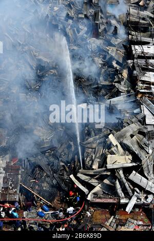 Dhaka, Bangladesh. 11th Mar, 2020. I vigili del fuoco spruzzano l'acqua per spegnere il fuoco in uno slum a Dhaka, Bangladesh, l'11 marzo 2020. Un enorme incendio scoppiò in una delle più grandi baraccopoli della capitale del Bangladesh, Dhaka Mercoledì, distruggendo centinaia di case e lasciando migliaia di sfollati. Credit: Str/Xinhua/Alamy Live News Foto Stock