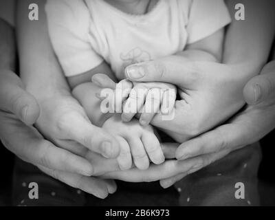 mani di famiglia completa: padre, madre e bambino. Foto Stock