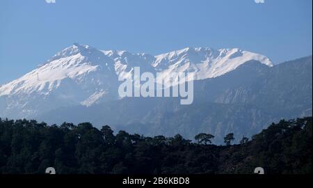 Paesaggio panoramico con montagne turche di diverse altezze, pini di montagna sulle piste e neve su alte cime finora Foto Stock