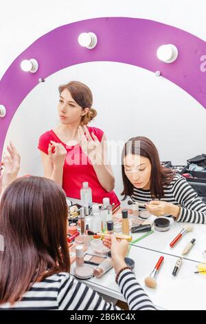 Ragazze amici imparare come applicare il trucco e utilizzare cosmetici in uno specchio bello in studio di bellezza, il concetto di amicizia e di studio Foto Stock