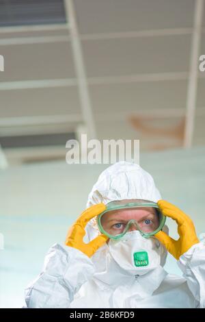 Ritratto di epidemiologo femminile in quarantena virale, colpo ravvicinato stretto di professionista medico in tuta di abbigliamento protettivo Foto Stock