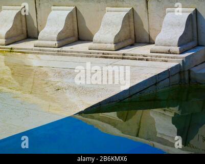 pietra bianca scolpita stile antico dettaglio architettonico di ordine colonna fregio. caduto, in parte sommerso in acqua piscina. decorativo classico dettaglio Foto Stock