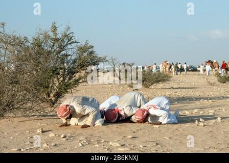 I musulmani pregano la Mecca - Makkah nel deserto del Qatar durante una visita reale del principe e della principessa del Galles di TRH novembre 1986 Foto Stock