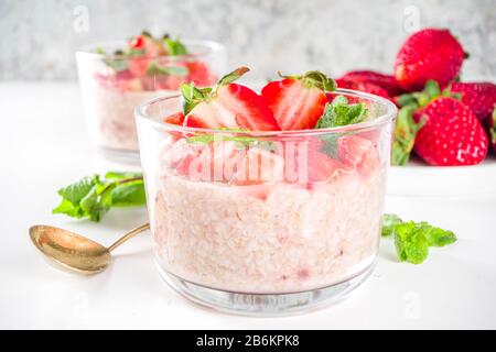 Set vari frutta durante la notte farinata d'avena. Porridge di avena con fragola, banane, cioccolato, noci in piccoli vasi porzione. Colazione estiva con farinata d'avena. Sano Foto Stock