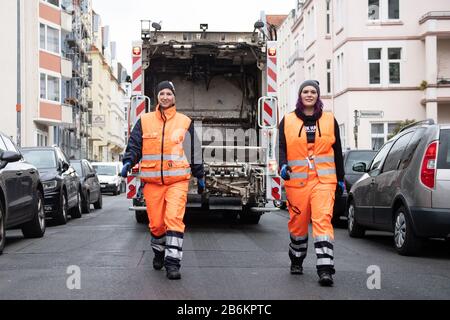 Hannover, Germania. 11th Mar, 2020. Gli addetti ai rifiuti Stefanie Celikdal (l) e Stephanie Höche sono in piedi su un veicolo per la raccolta dei rifiuti. A seguito di una data di lavoro nel mese di agosto 2019, la Regione di Hannover Zweckverband Abfallwirtschaft ha occupato quattro donne nel reparto di raccolta dei rifiuti dell'associazione. In molte città, la raccolta dei rifiuti è ancora un dominio puramente maschile. Credito: Swen Pförtner/Dpa/Alamy Live News Foto Stock