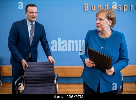 Berlino, Germania. 11th Mar, 2020. Il Cancelliere Angela Merkel si avvicina a Jens Spahn (CDU, l), Ministro federale della sanità, dopo una conferenza stampa sullo sviluppo del coronavirus. Credito: Michael Kappeler/Dpa/Alamy Live News Foto Stock