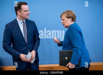 Berlino, Germania. 11th Mar, 2020. Il Cancelliere Angela Merkel si avvicina a Jens Spahn (CDU, l), Ministro federale della sanità, dopo una conferenza stampa sullo sviluppo del coronavirus. Credito: Michael Kappeler/Dpa/Alamy Live News Foto Stock