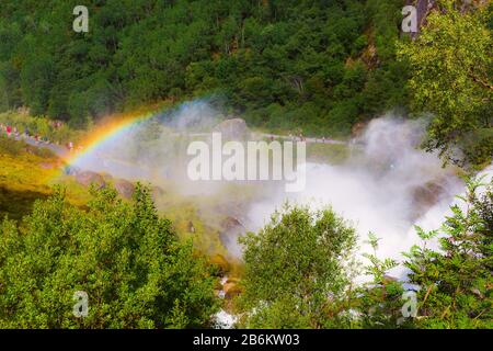 La cascata e rainbow sul modo di Briksdal o ghiacciaio Briksdalsbreen in Olden, Norvegia e montagne verdi Foto Stock