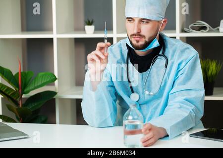 Il medico entra in una soluzione iniettabile in una siringa Foto Stock