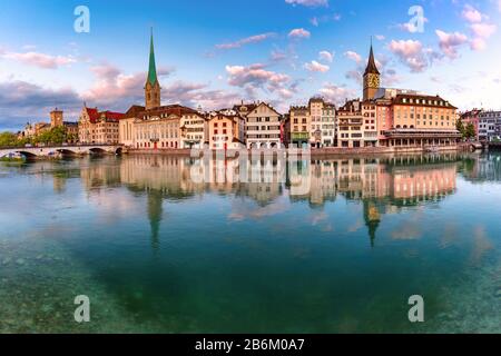 Vista panoramica del famoso Fraumunster, della chiesa di San Pietro e del fiume Limmat all'alba nel centro storico di Zurigo, la città più grande della Svizzera Foto Stock