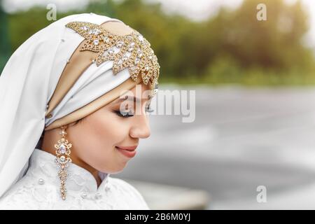 Affascinante sposa araba musulmana in nikah abito da sposa e hijab Headscarf, primo piano su gioielli e orecchini Foto Stock