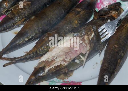 Lo sgombro di pesce fresco affumicato è caldo su un piatto di ceramica Foto Stock