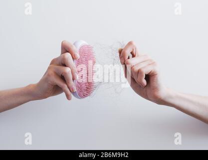 Femmina con pettine e capelli problematici su sfondo bianco. Foto Stock