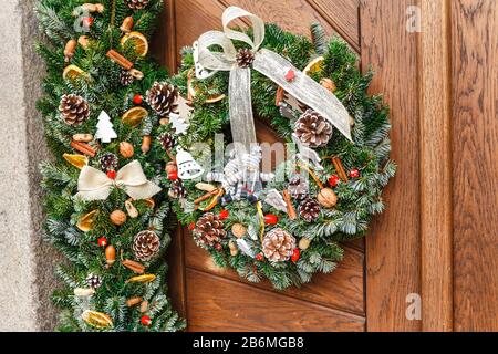 Corona di Natale appesa su una porta di legno Foto Stock