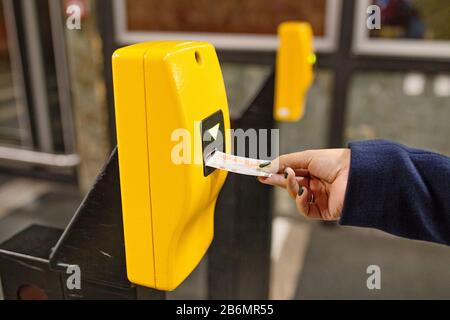 Donna punzonatura biglietto in convalida dispositivo macchina per entrare alla stazione della metropolitana di Praga Foto Stock