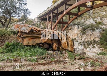 Male abbandonato bruciato fuori macchina a lato della strada, Spagna. Foto Stock