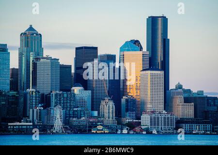 Skyline di grattacieli sul lungomare al tramonto, Seattle, Washington, Stati Uniti Foto Stock