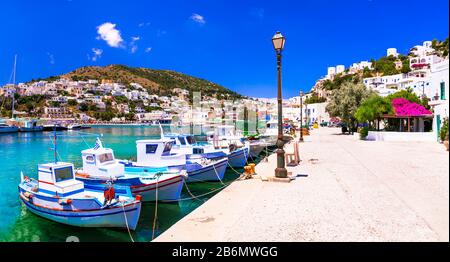 Mare turchese, barche da pesca tradizionali, case bianche e mulini a vento, Panteli villaggio, Leros, Grecia. Foto Stock