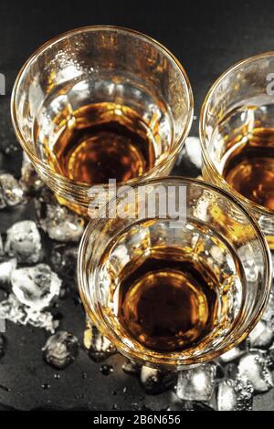 Whisky e ghiaccio su sfondo rustico in legno Foto Stock