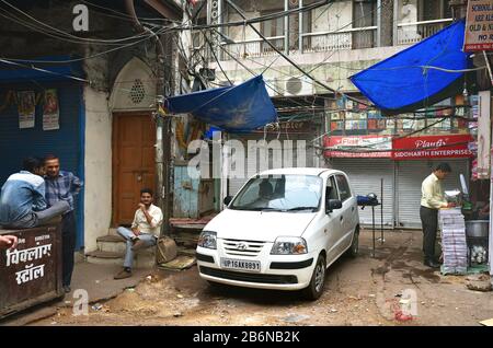 Old Delhi, India - 7th Novembre 2019: Auto bianca parcheggiata fuori dai negozi Foto Stock