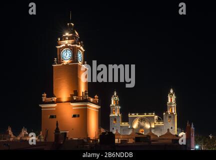 Torre di Palacio Municipal, Catedral de San Ildefonso in lontananza, di notte, Merida, Stato dello Yucatan, Messico Foto Stock