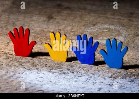 Colorfull puzzle mani su tavola di legno. Concetto Della Giornata Mondiale Della Consapevolezza Dell'Autismo Foto Stock