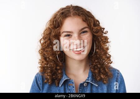 Gioioso amichevole-osservare giovane 20s ragazza studente riccio capelli freckles pimples fronte sorridente ampiamente parlando si guarda fotocamera piacevolmente felice Foto Stock