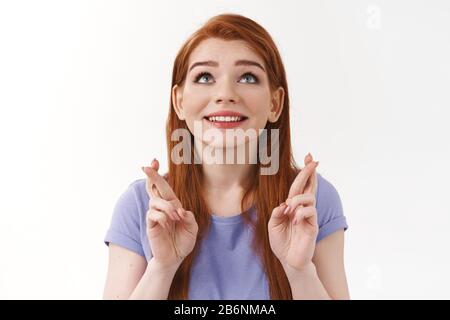 Primo piano sparato sognante, fiducioso cute millennial redhead femmina studente in t-shirt, guardando il cielo, sorridente upbeat ed eccitato, vogliono sogno diventare realtà Foto Stock