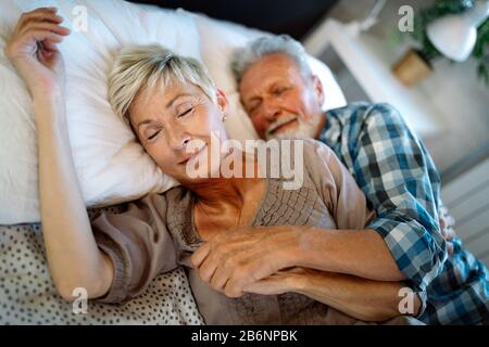 Sorridenti coppia senior abbracciando insieme a casa Foto Stock