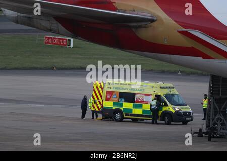 Un membro del NHS West Midlands Ambulance Service, indossando indumenti protettivi e una maschera facciale, parla ai passeggeri (a sinistra) dalla nave da crociera Grand Princess, colpita dal coronavirus, dopo che sono arrivati all'aeroporto di Birmingham dopo il loro rimpatrio nel Regno Unito dagli Stati Uniti. Foto PA. Data Immagine: Mercoledì 11 Marzo 2020. Circa 140 vacanzieri britannici erano stati bloccati sulla nave al largo della costa occidentale dell'America dopo che 21 persone hanno provato positivo per il virus a bordo. Vedi la storia PA SALUTE Coronavirru. Photo credit dovrebbe leggere: Steve Parsons/PA Wire Foto Stock