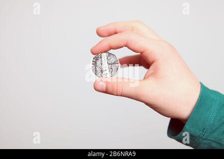 Mano di un bambino che tiene in mano un raro giardino Kew 2009 50p tra le dita, 50 pence, 2020 Foto Stock