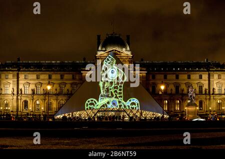 Collezione Louvre esposta su un ingresso a piramide di vetro in serata, Parigi, Francia Foto Stock