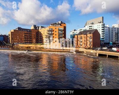 Moderni edifici di appartamenti sul fiume Aire in spate a causa delle recenti tempeste di pioggia Leeds West Yorkshire Inghilterra Foto Stock