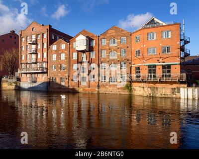 Facciata del fiume di ex Fletland Mills convertito magazzini edifici dal fiume Aire a Chiamate Landing a Leeds West Yorkshire Inghilterra Foto Stock