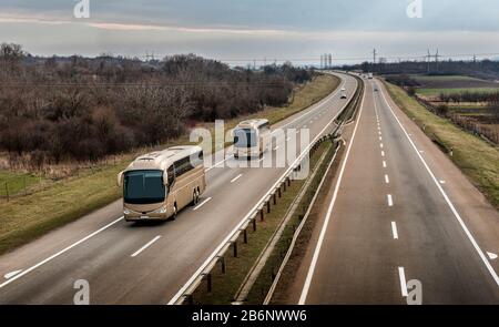 Due autobus in linea che viaggiano su un'autostrada di campagna Foto Stock