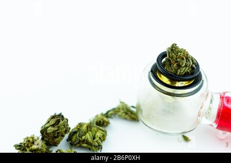 Boccioli di cannabis in un tubo di fumo di vetro, macro fotografia. Medicina concetto di cannabis Foto Stock