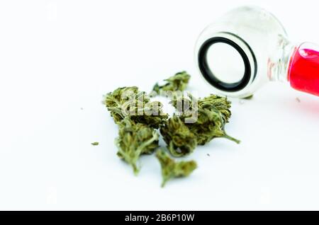 Coni di cannabis medica e un tubo di fumo di vetro sullo sfondo Foto Stock