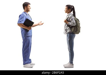 Scatto di profilo a lunghezza intera di un medico maschio che prende ad uno studente femminile isolato su sfondo bianco Foto Stock