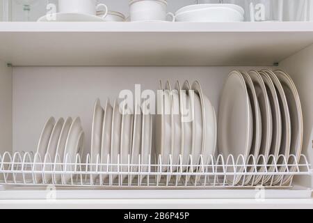 set di piastre sul ripiano nel mobile della cucina Foto Stock