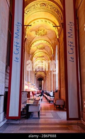 Situato sotto i portici del museo del Louvre , il Cafe Marly è la perfetta miscela di una brasserie parigina e di un caffè letterario. Parigi. Francia. Foto Stock