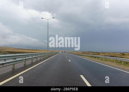 Traffico sulla nuova strada A-290 (ex M25) sulla penisola di Taman in una nuvolosa giornata d'autunno. L'autostrada fa parte della linea europea E97 Foto Stock