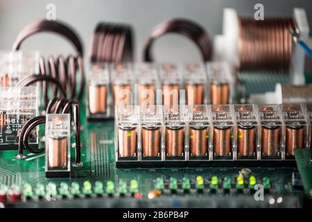 Primo piano dei canali e dei passaggi su un microcircuito collegato in una fabbrica di apparecchiature elettriche. Il concetto di apparecchiature moderne testate nel tempo Foto Stock