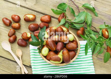 Cesto di vimini con frutta Ziziphus real, capiente, jujube, cinese data, capiinit, jojoba, cinese-data (lat.Ziziphus jujuba) sul tavolo. Raccolto Foto Stock