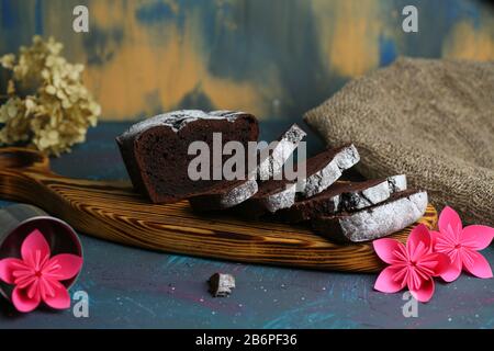 Muffin al cioccolato affettato si trovano su un tagliere. Sfondo Foto Stock